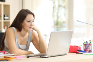 A young female student is studying on her laptop